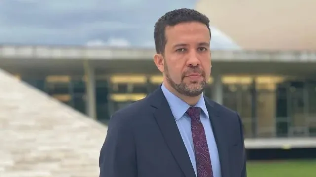 Uma mão segurando um smartphone com um aplicativo de mensagens, e o símbolo da Justiça Eleitoral sobreposto, em um cenário digital e dinâmico.