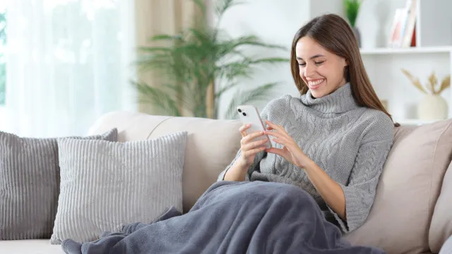 Pessoa em frente a uma tela interativa, provando roupas virtualmente em um ambiente moderno e iluminado.
