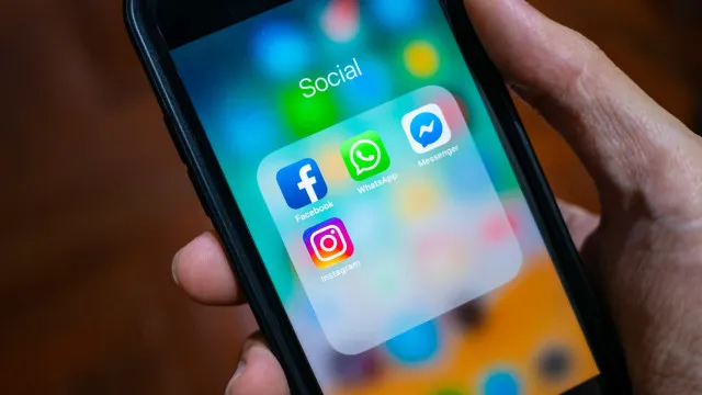 Tela de smartphone com aplicativo de mensagens aberto, representando comunicação digital em ambiente de trabalho