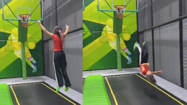 Uma menina de collant de ginástica está no ar, após um salto em um trampolim, em uma aula de ginástica.