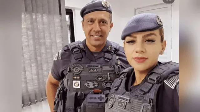 Uma mesa de tribunal com papéis espalhados e um martelo, com o banco do juiz desfocado ao fundo.