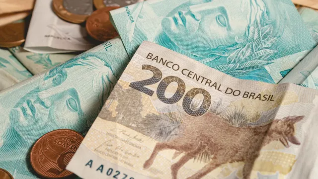 Uma ilustração do aplicativo de apostas em um celular, com gráficos e moedas digitais ao redor.