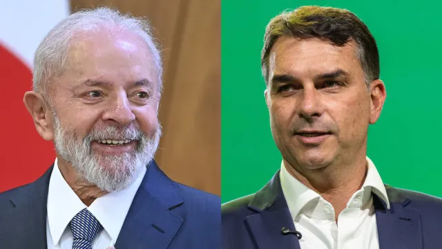 Palco de debate político vazio, com dois púlpitos e telão ao fundo, iluminado por luzes de estúdio.