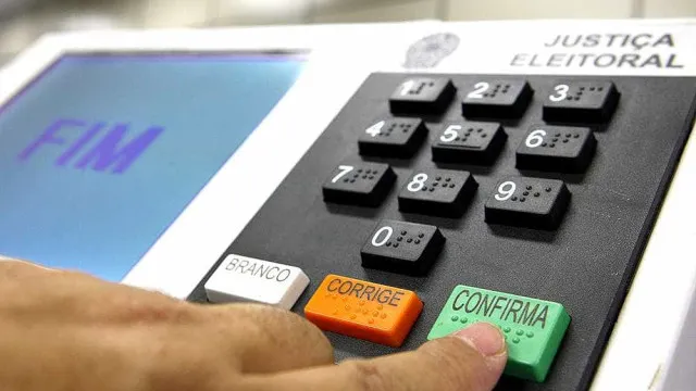 Bottons e adesivos coloridos de campanha com nomes inusitados e slogans excêntricos sobre uma mesa de madeira.