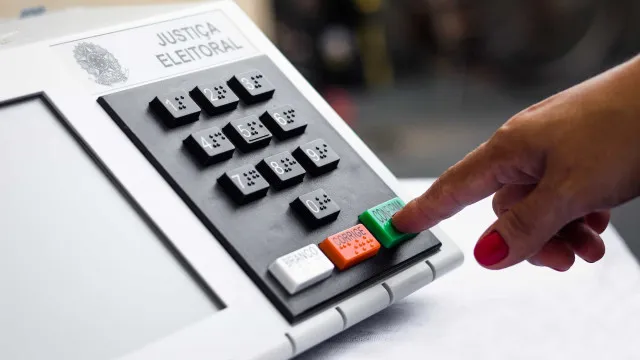 Fachada de prédio universitário português com seções de votação instaladas e urnas eleitorais visíveis