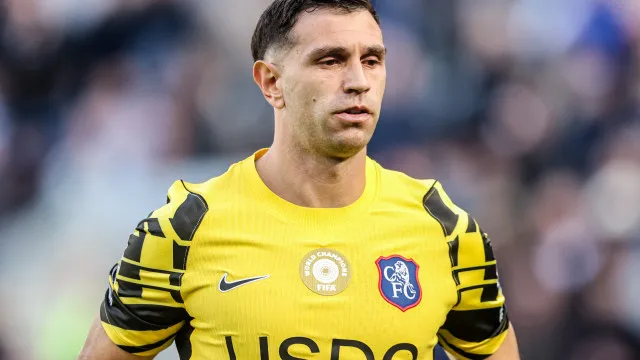 Uma representação estilizada de uma baliza de futebol com uma bola desfocada no ar.