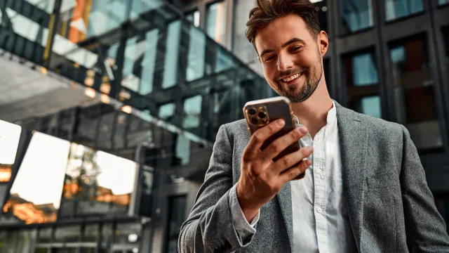 Um smartphone com ícones de aplicativos de segurança na tela, sobrepostos por um cadeado brilhante. Uma mão segura o aparelho em um ambiente com foco suave.