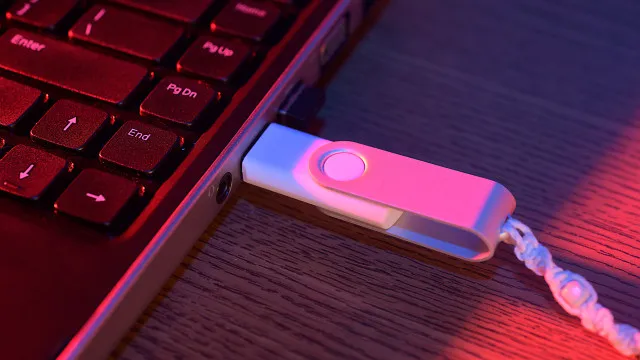Ilustração mostrando pen drive e dispositivo externo conectados a porta USB do computador com ícone de ejeção visível na tela