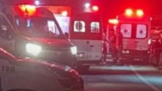 Ilustração de ônibus de turismo tombado em rodovia, com equipes de resgate atuando no local à noite