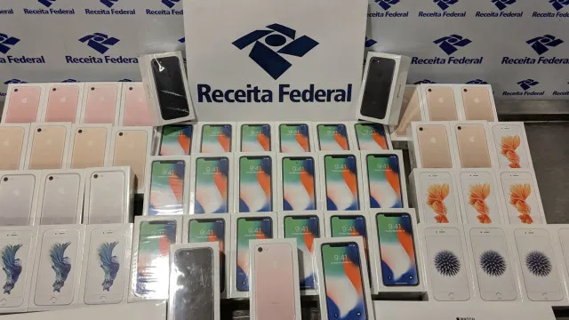 Eletrônicos e eletrodomésticos expostos com etiquetas de preço em ambiente de leilão