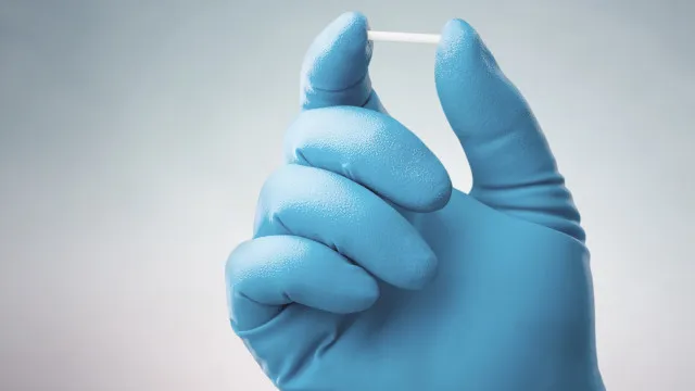 Consultório médico com profissional de saúde analisando documentos durante consulta com paciente