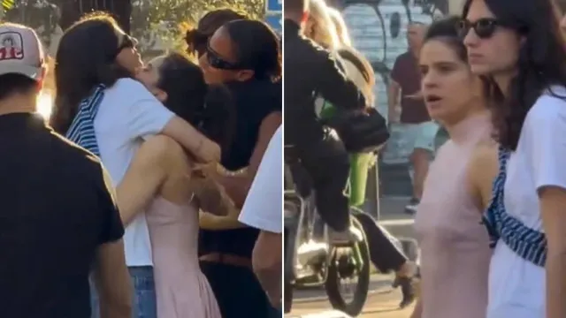 Casal caminhando de mãos dadas pelas ruas de Paris, com arquitetura clássica ao fundo e luz dourada do fim de tarde